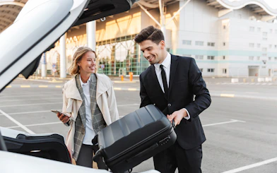 Private transfer service at London Stansted Airport with driver loading luggage.