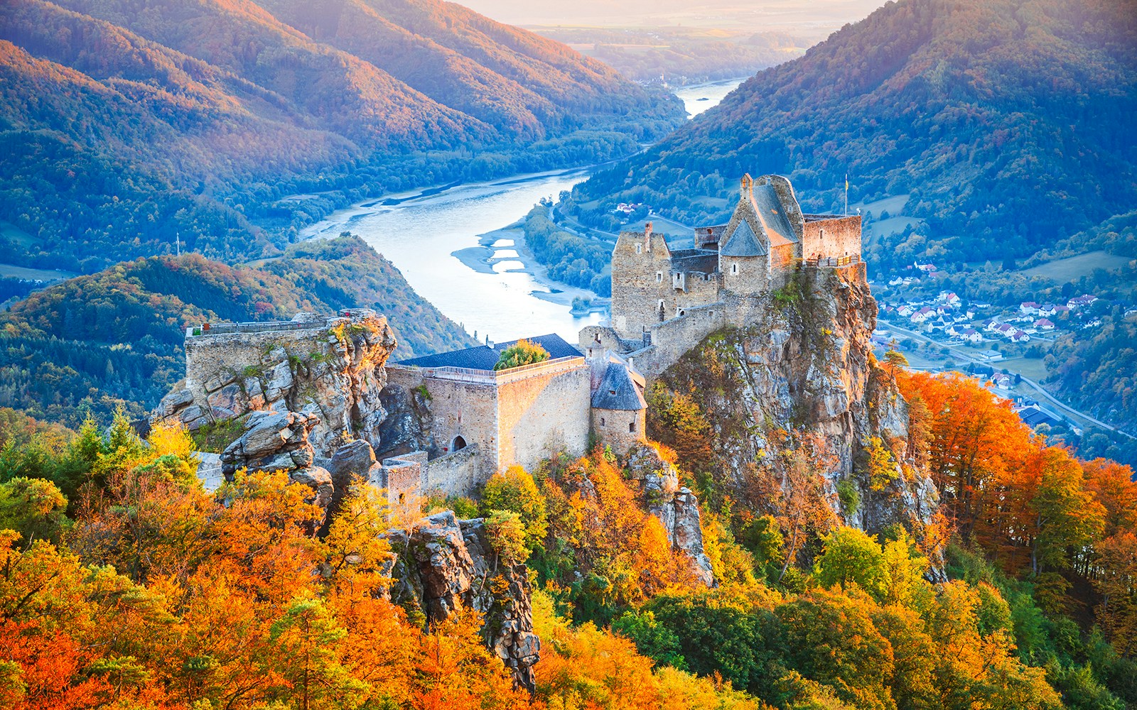 Aggstein Castle ruins overlooking Wachau Valley with autumn foliage and winding river.