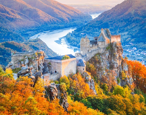 Aggstein Castle ruins overlooking Wachau Valley with autumn foliage and winding river.