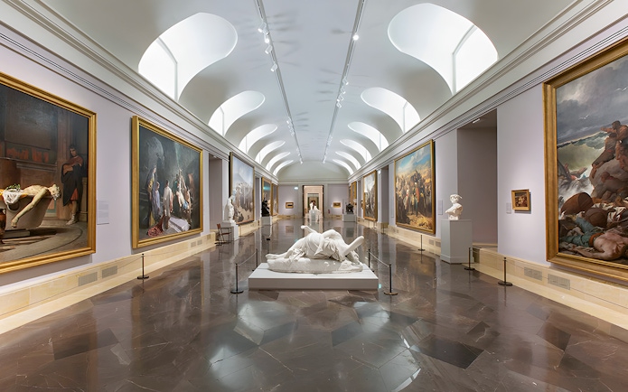 Prado Museum gallery with classical paintings and sculptures on display.