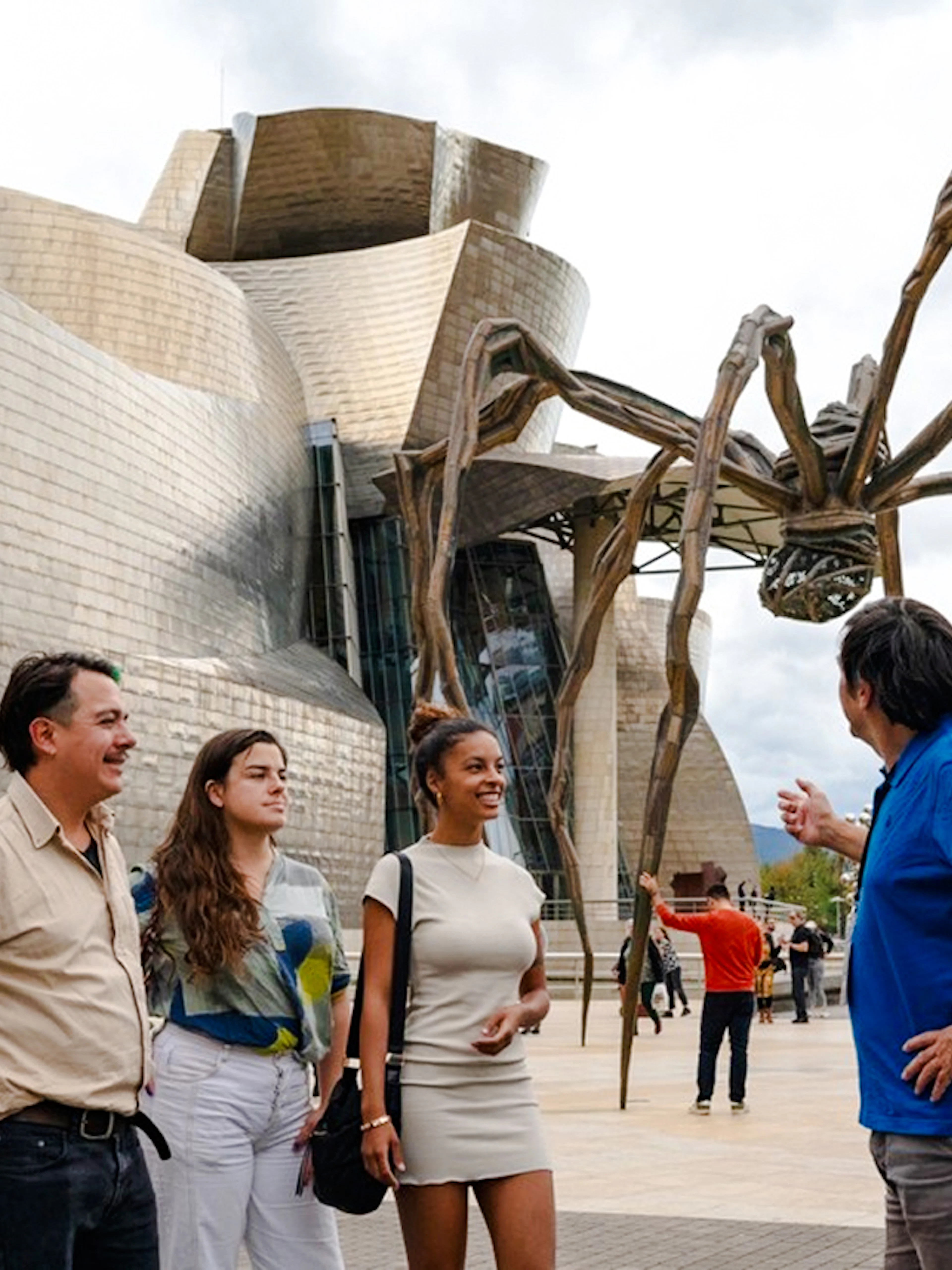 Visitors at Guggenheim Museum Bilbao with spider sculpture during private tour from San Sebastian.
