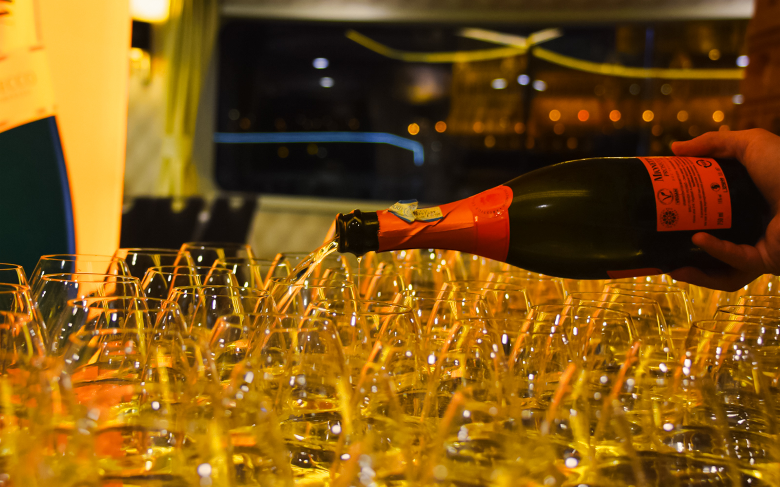 Pouring Prosecco into glasses on a 90-minute sightseeing cruise.