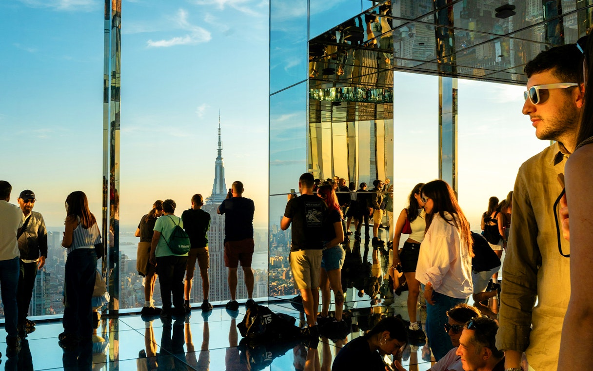 Visitors viewing the Empire State Building at sunset from Summit One Vanderbilt, Manhattan.