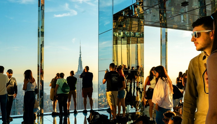 Visitors viewing the Empire State Building at sunset from Summit One Vanderbilt, Manhattan.