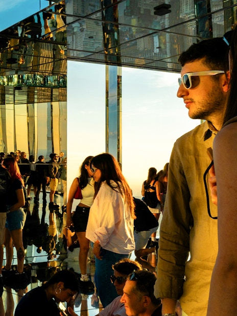 Visitors viewing the Empire State Building at sunset from Summit One Vanderbilt, Manhattan.