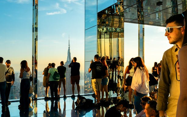 Visitors viewing the Empire State Building at sunset from Summit One Vanderbilt, Manhattan.
