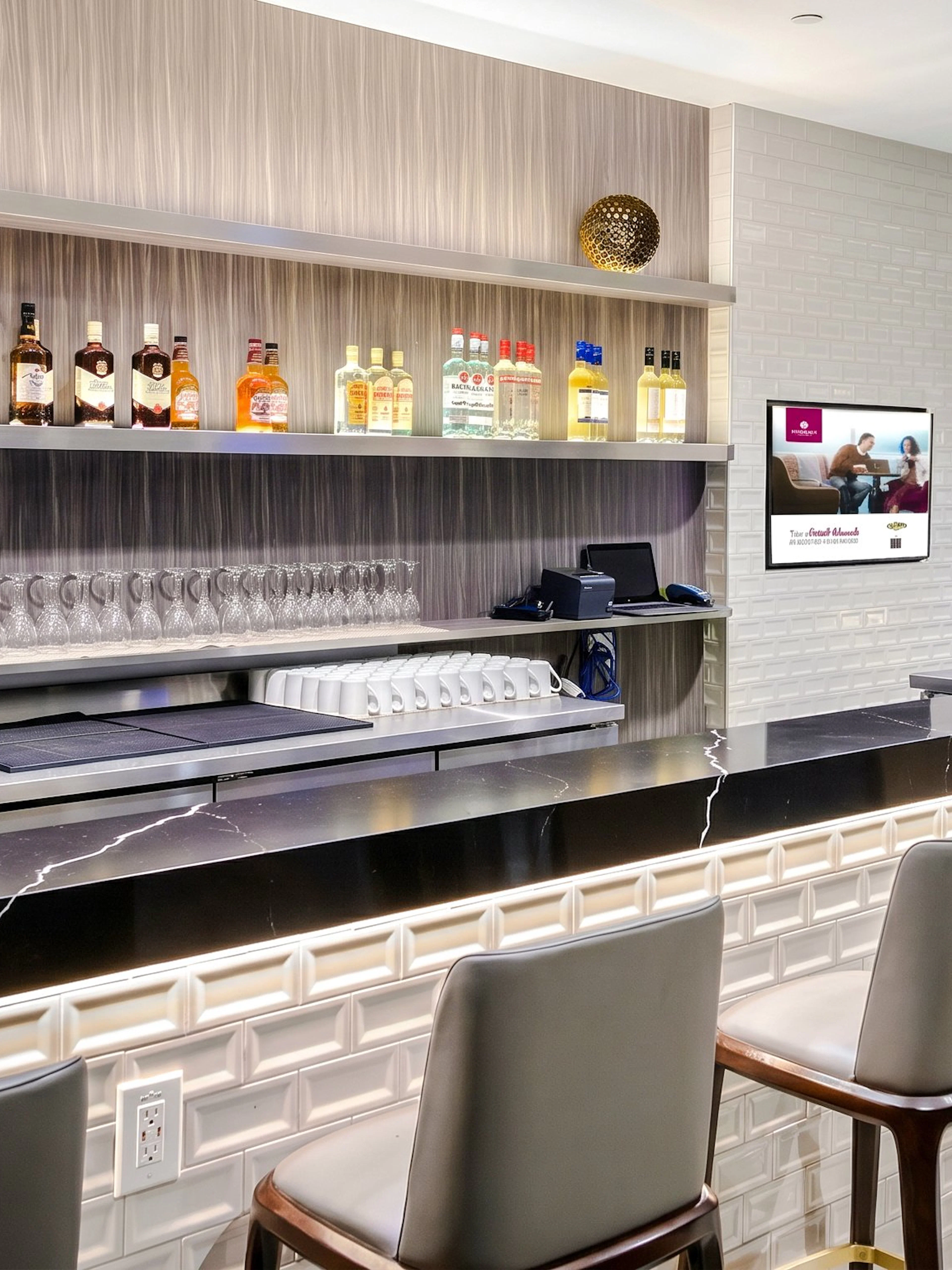 Bar counter at Plaza Premium Lounge, Terminal 1, Toronto Pearson Airport, with bottles and glasses displayed.