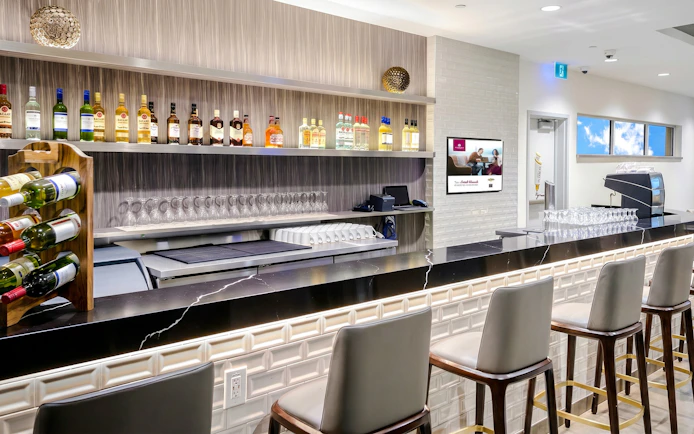 Bar counter at Plaza Premium Lounge, Terminal 1, Toronto Pearson Airport, with bottles and glasses displayed.