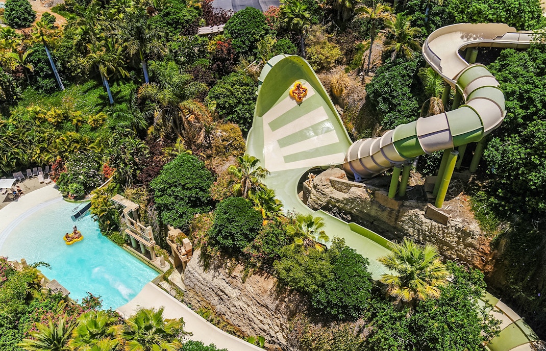 Tourists on Kinnaree ride at Siam Park, Tenerife, experiencing thrilling water slide adventure.