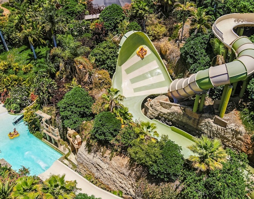Tourists on Kinnaree ride at Siam Park, Tenerife, experiencing thrilling water slide adventure.