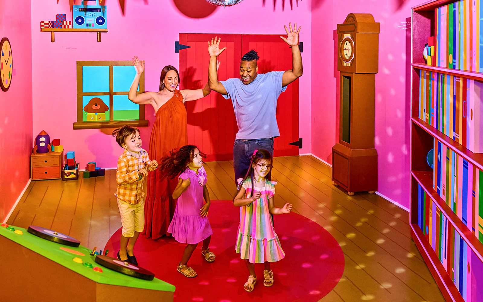 Children and adults enjoying CBeebies Rainbow Adventure interactive room.
