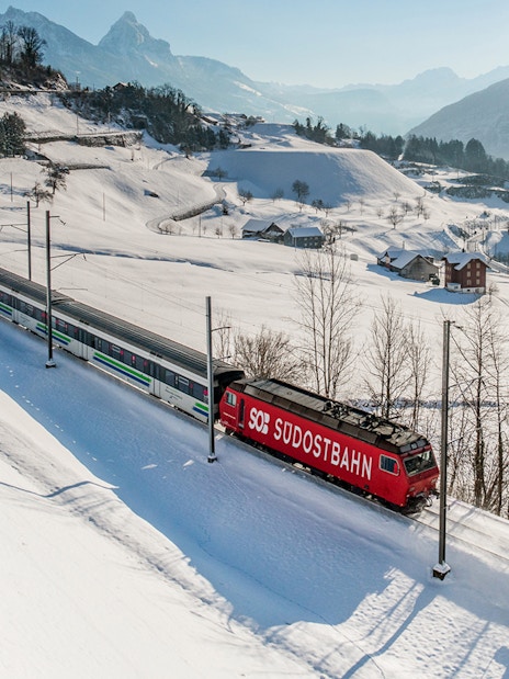 Train traveling through snowy Swiss Alps landscape with Swiss Travel Pass.