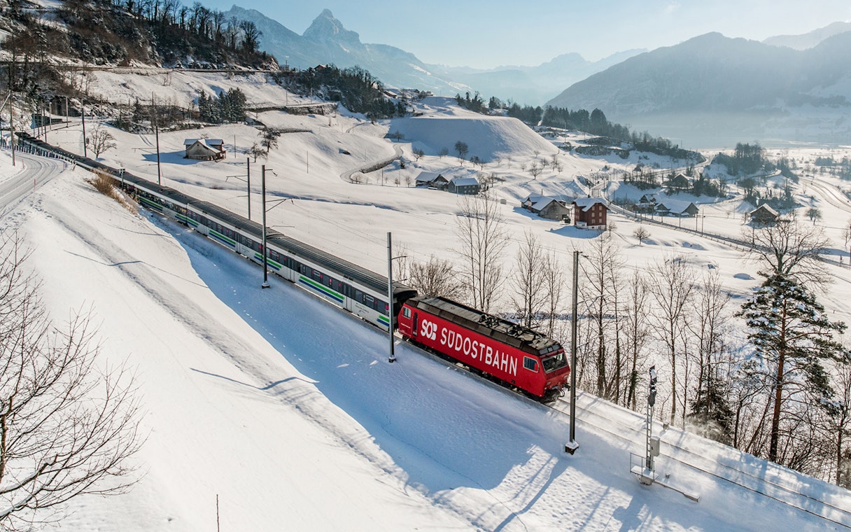 Train traveling through snowy Swiss Alps landscape with Swiss Travel Pass.