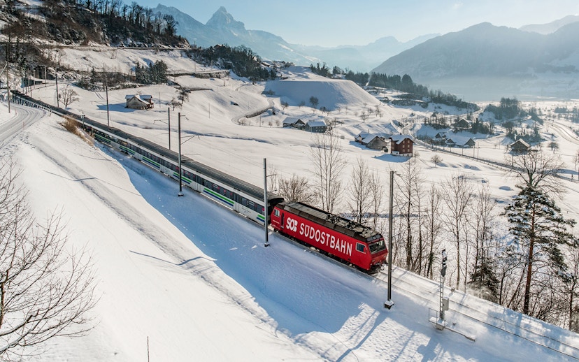 Train traveling through snowy Swiss Alps landscape with Swiss Travel Pass.