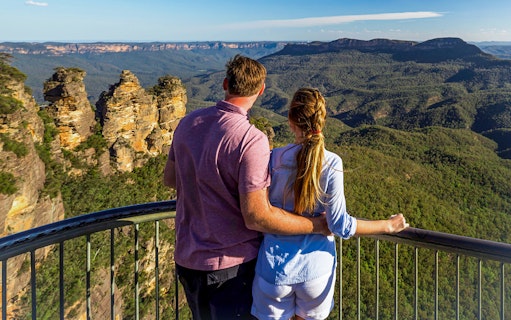 Couple admiring the Three Sisters rock formation in Blue Mountains, Australia.