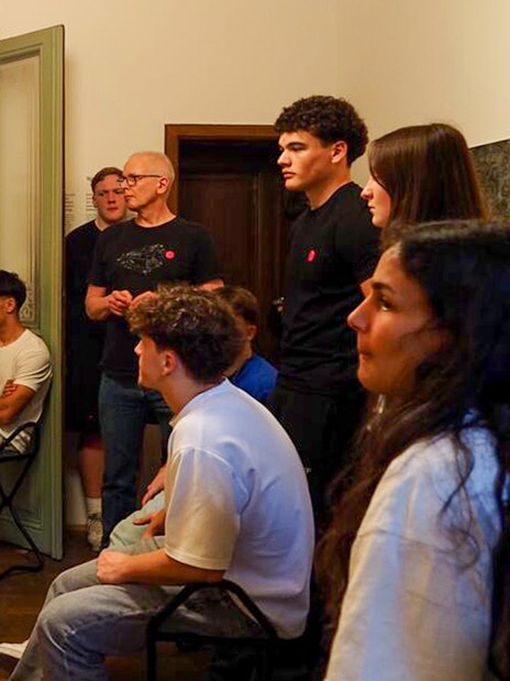 Guide leading tour inside Sigmund Freud Museum, Vienna, with visitors observing historical exhibits.