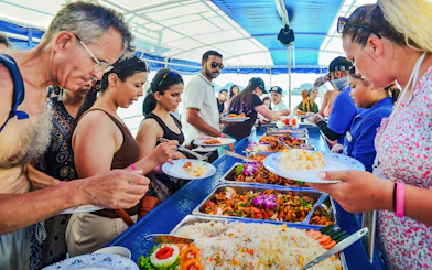 Tourists enjoying buffet lunch on a boat tour at Phang Nga Bay, Thailand.