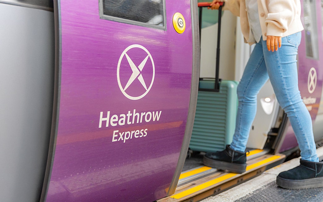 Heathrow Express train door with passenger boarding.
