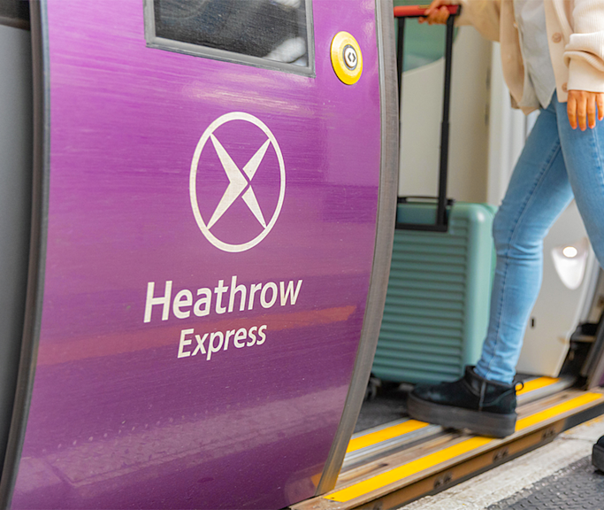 Heathrow Express train door with passenger boarding.