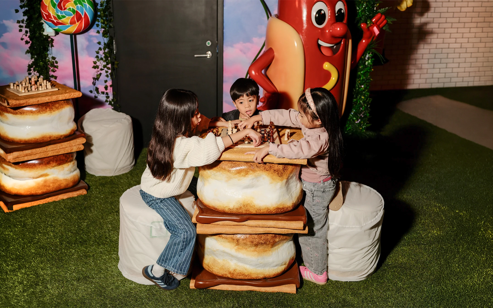 Children playing chess at a marshmallow-themed table in the iCandy Experience, NYC.