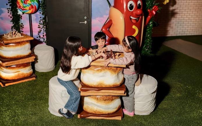 Children playing chess at a marshmallow-themed table in the iCandy Experience, NYC.