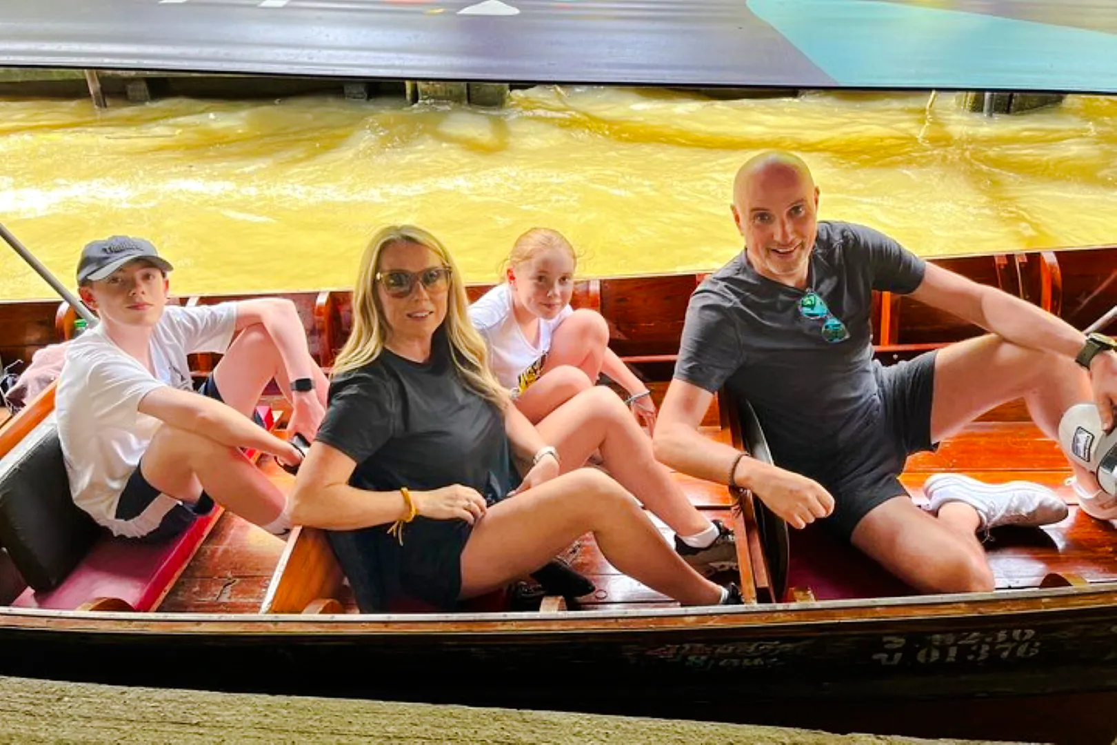 Family enjoying a boat ride at a floating market on the Floating Market & Railway Market tour from Laem Chabang, Pattaya.