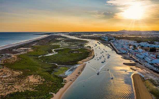 Aerial view of Ria Formosa lagoon and boats near Faro during sunset on 4 Islands Guided Tour.