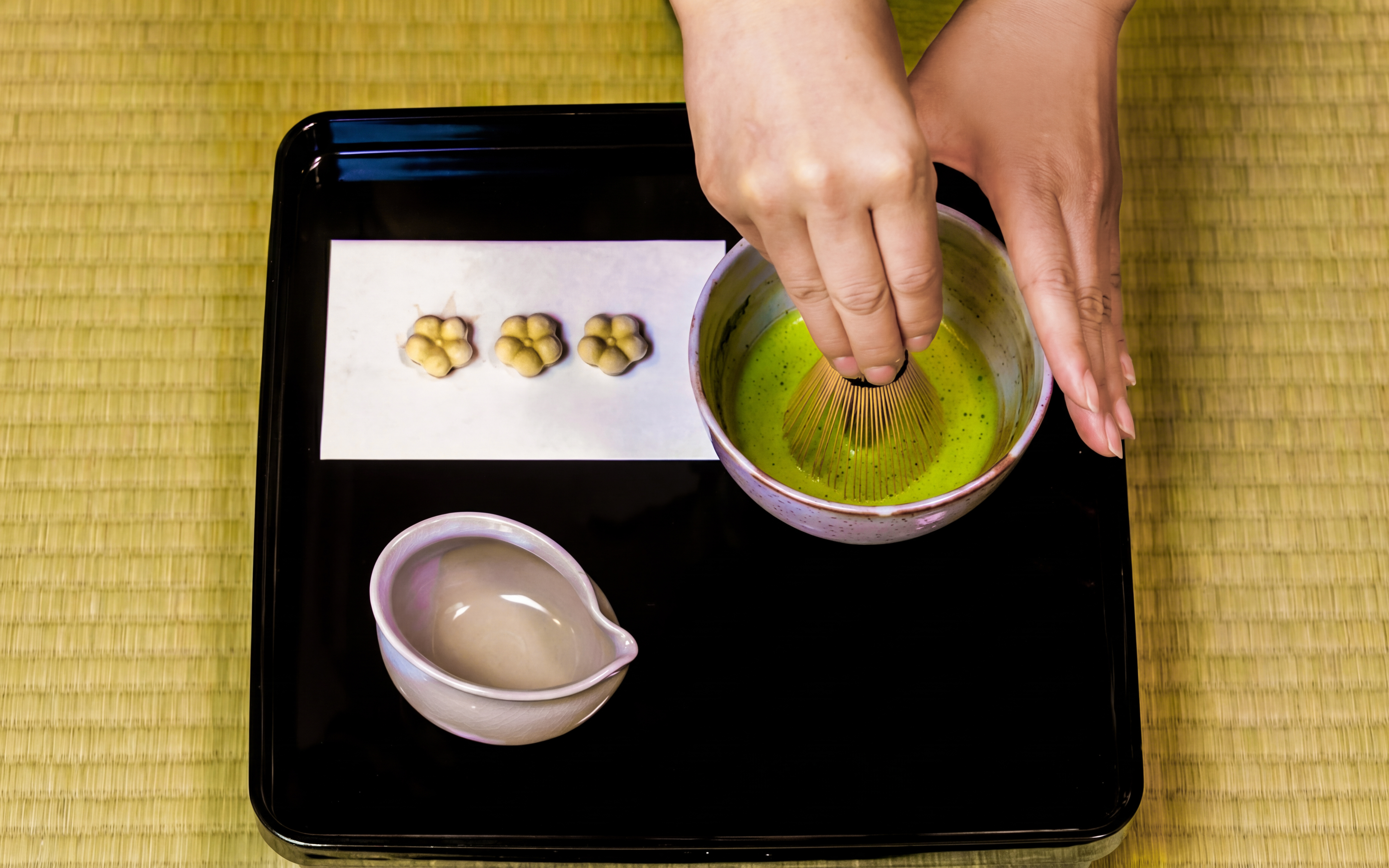 Matcha being whisked in a bowl during a traditional tea ceremony experience.