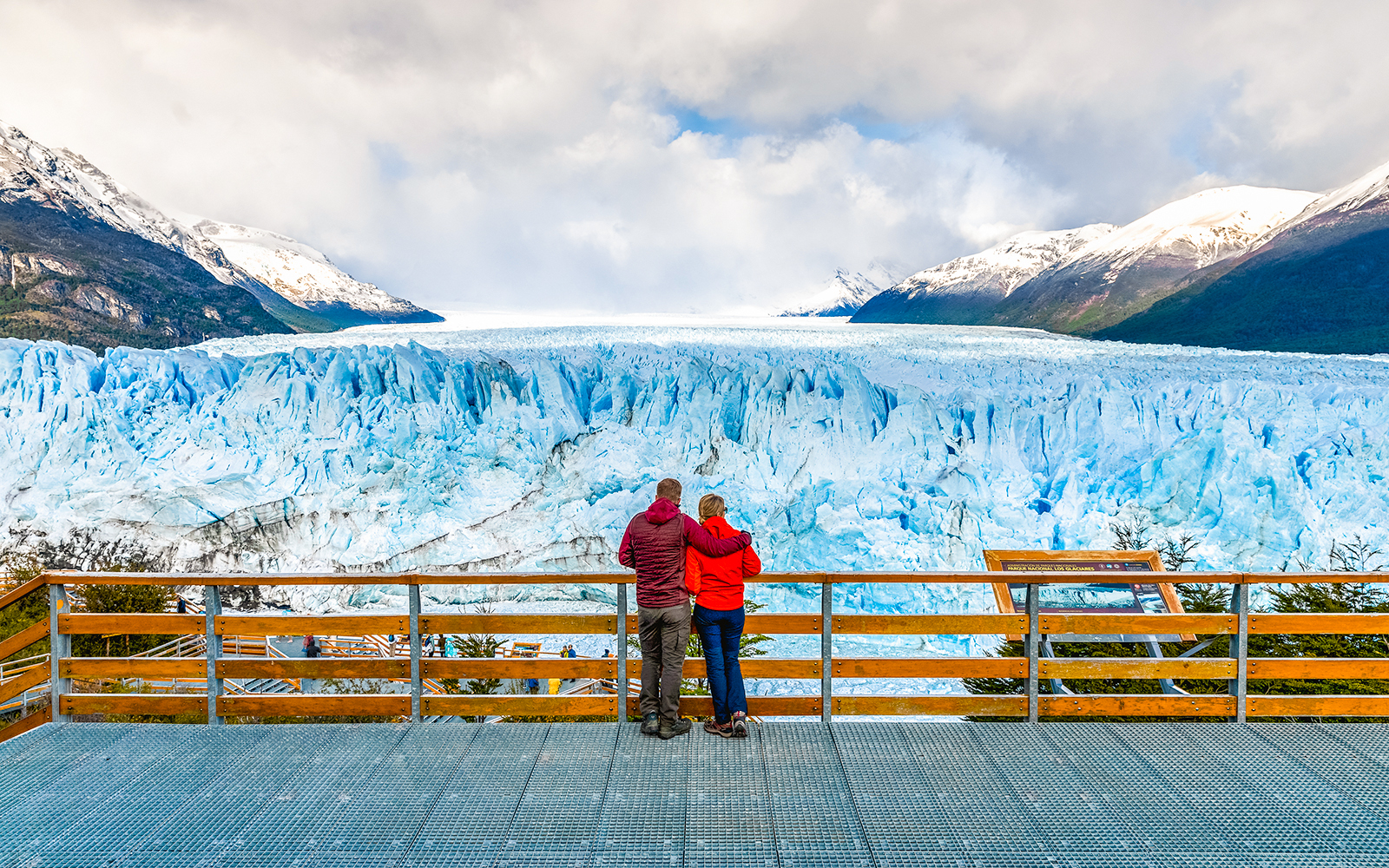 Couple admiring Perito Moreno Glacier from viewing deck in Argentina.