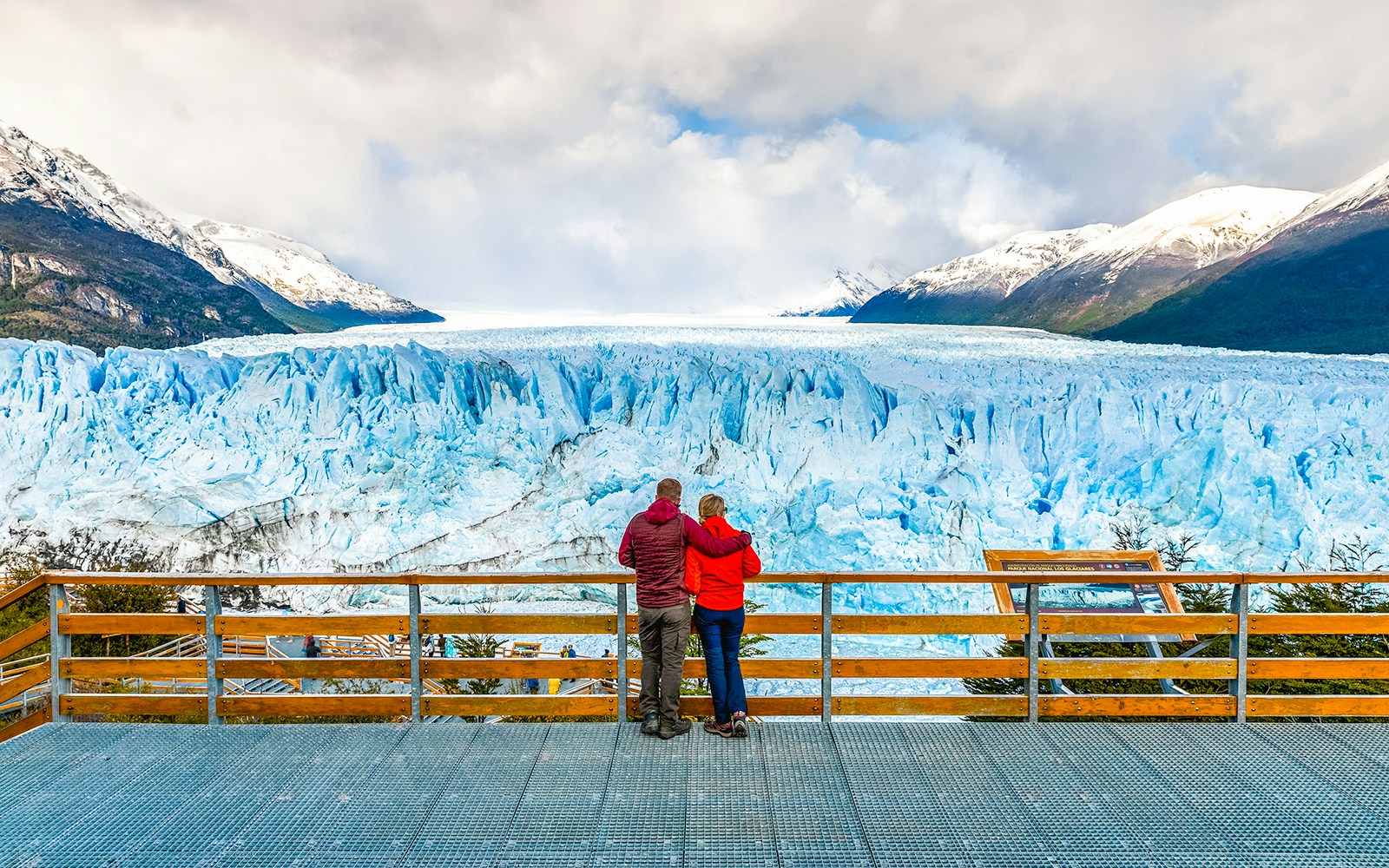 Couple admiring Perito Moreno Glacier from viewing deck in Argentina.