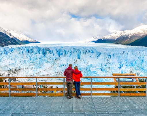 Couple admiring Perito Moreno Glacier from viewing deck in Argentina.
