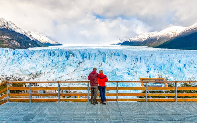 Couple admiring Perito Moreno Glacier from viewing deck in Argentina.