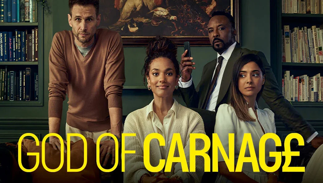 Cast of "God of Carnage" in a library setting with bookshelves and artwork.