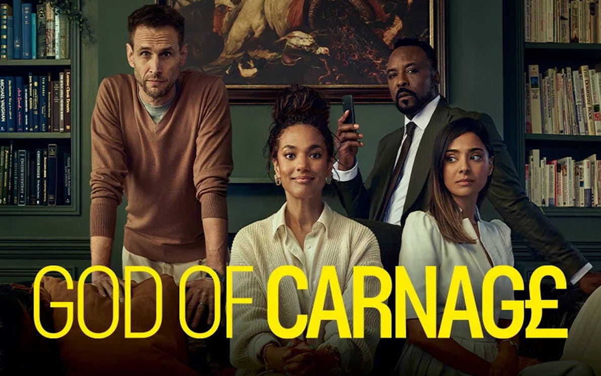 Cast of "God of Carnage" in a library setting with bookshelves and artwork.