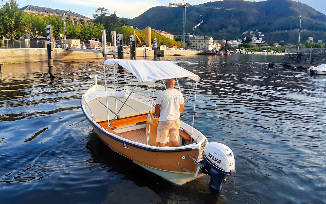 Boat rental on Lake Como with scenic mountain and waterfront views.