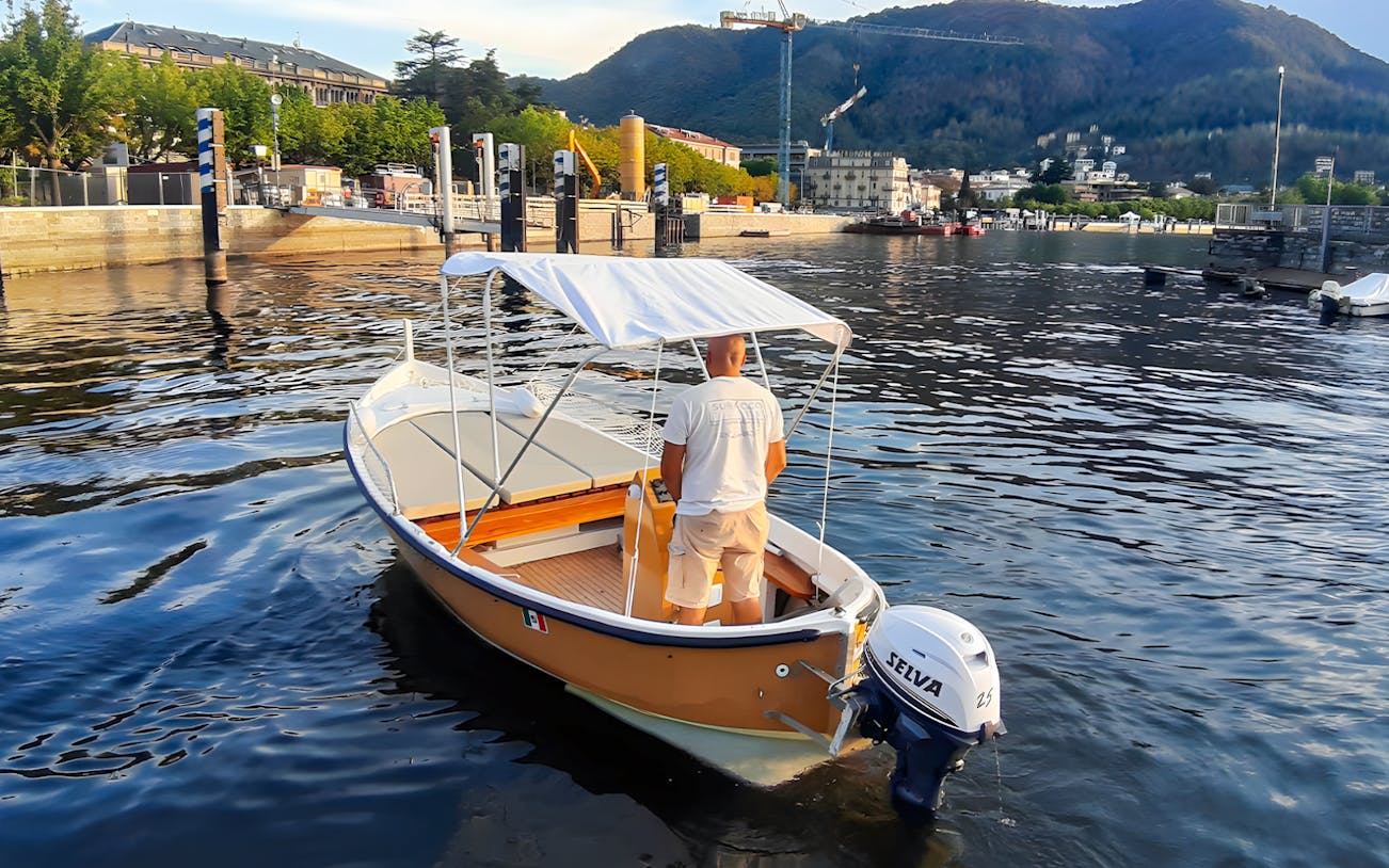 Boat rental on Lake Como with scenic mountain and waterfront views.