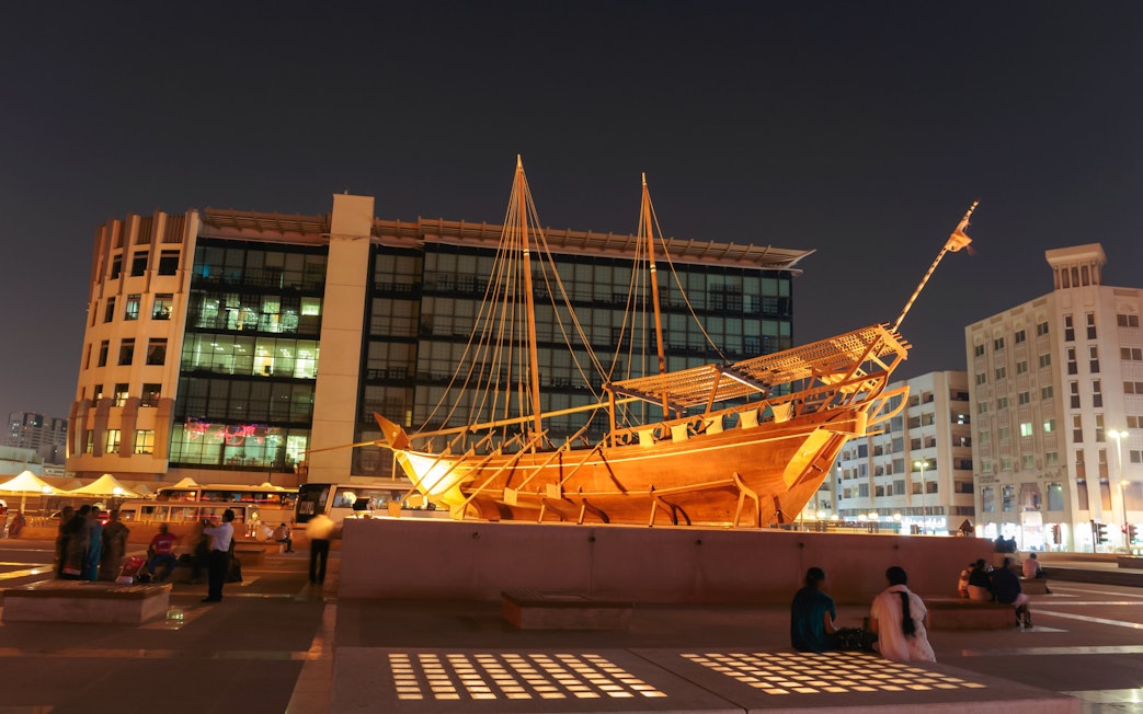 Wooden dhow boat displayed at night near Al Fahidi Fort, Dubai.