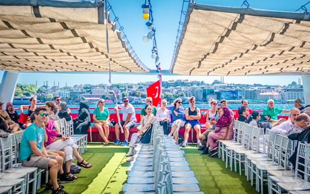 Guests on a Bosphorus sightseeing cruise with Istanbul skyline in the background.