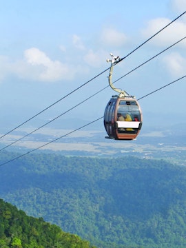 Langkawi Cable Car over lush green hills with distant skybridge view.