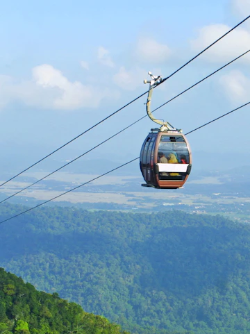 Langkawi Cable Car over lush green hills with distant skybridge view.