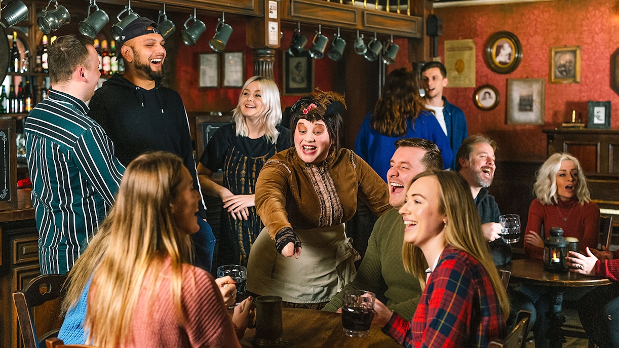 Visitors enjoying drinks with costumed characters at London Dungeon.