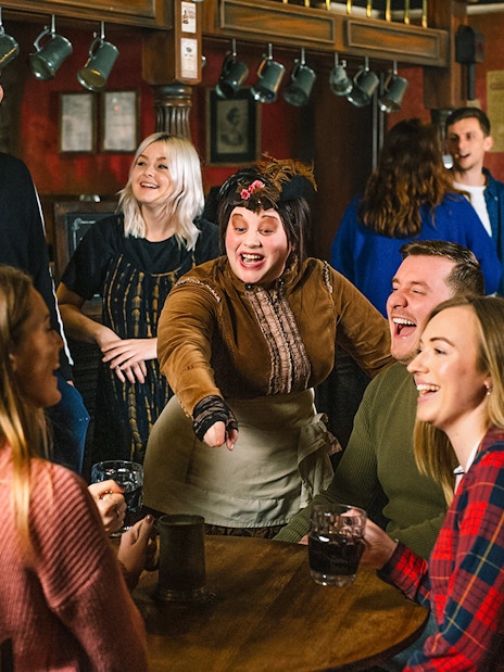 Visitors enjoying drinks with costumed characters at London Dungeon.