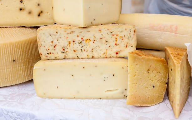 Assorted French cheeses on display during a gourmet food tour in Paris.