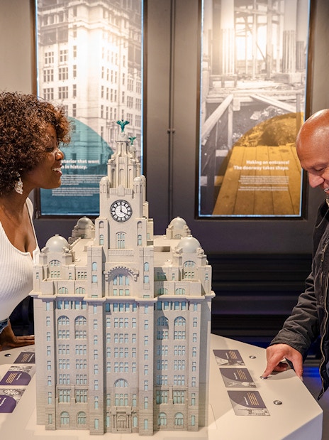 Guests examining a model of the Royal Liver Building exhibits.
