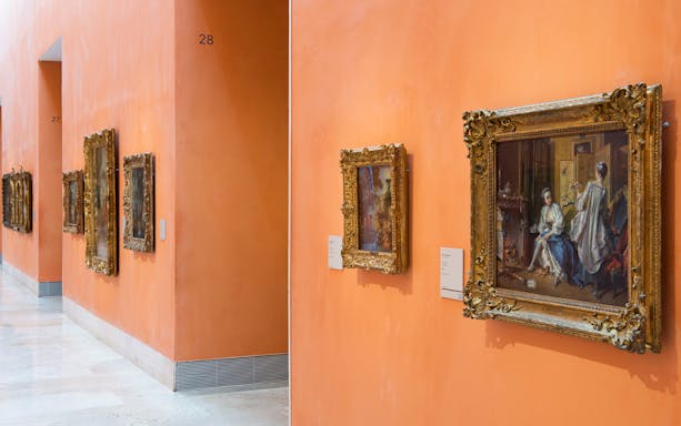 Thyssen-Bornemisza Museum gallery with framed paintings on orange walls.