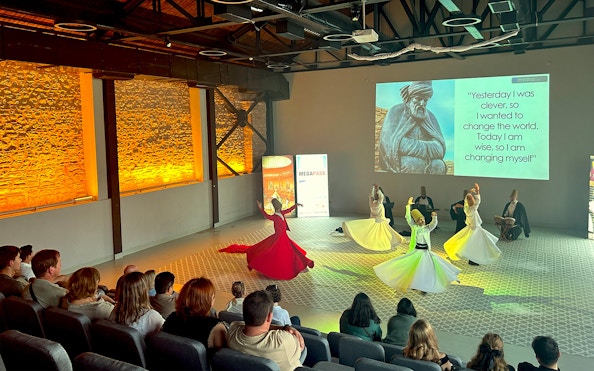 Whirling Dervishes performing in a ceremony with an audience in Istanbul.