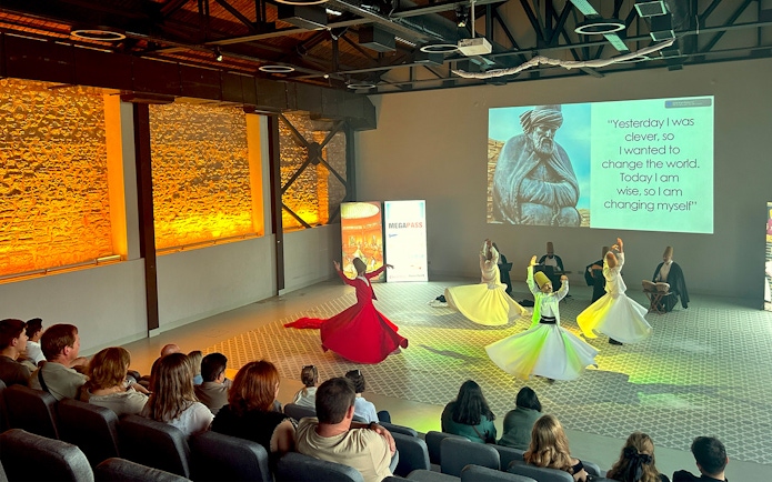 Whirling Dervishes performing in a ceremony with an audience in Istanbul.