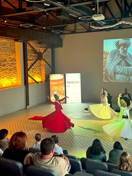 Whirling Dervishes performing in a ceremony with an audience in Istanbul.