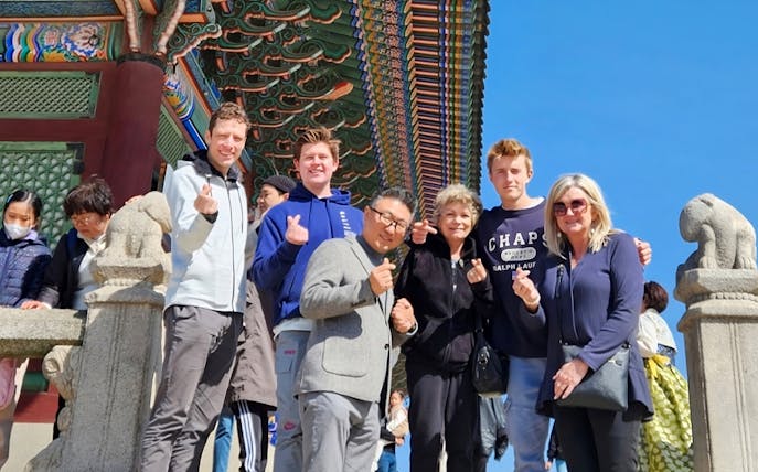 Group of tourists posing at a traditional Korean temple during a private walking tour in Seoul.