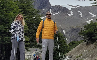Tourists hiking on Ushuaia Martial Glacier trail with snowy peaks in the background.